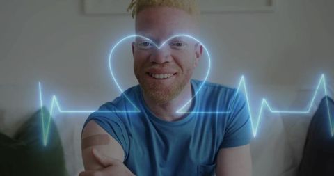 Smiling man showing vaccination bandage with neon ecg heartbeat line promoting wellness