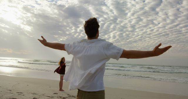 Man Enjoying Ocean Breeze with Partner on Calm Beach - Download Free Stock Images Pikwizard.com