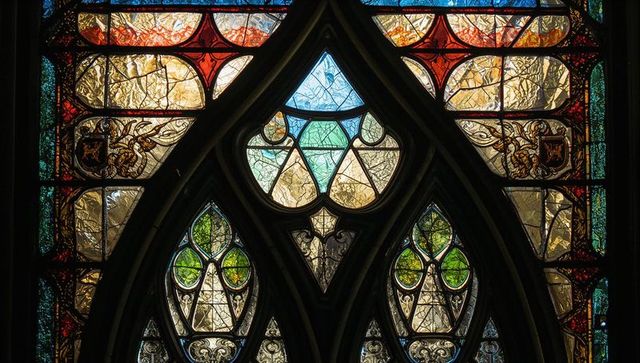 Intricate gothic stained glass in cathedral setting