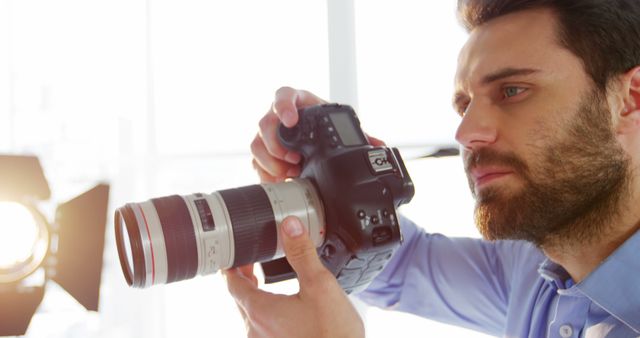 Male Photographer Adjusting Camera at Studio Shoot - Download Free Stock Images Pikwizard.com