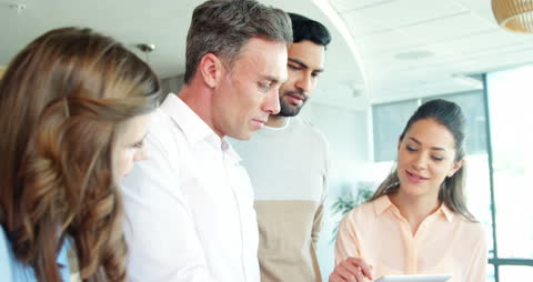 Diverse Team Collaborating on Tablet in Bright Office