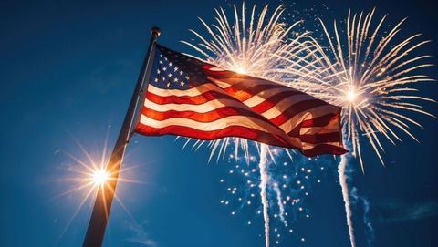 Waving american flag with colorful fireworks display