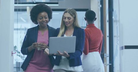 Businesswomen Collaborating in Modern Office Corridor