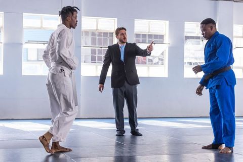 Martial Arts Training with Referee Guiding Two Fighters Pre-Sparring