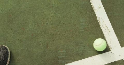 Tennis Ball on Green Court Near Athlete's Footwear