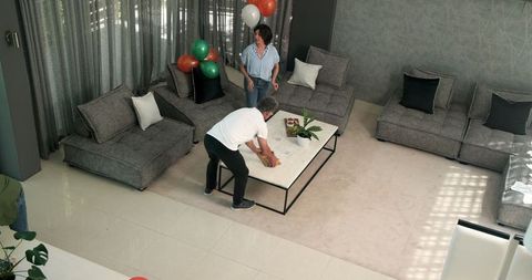 Diverse Couple Decorating Room with Balloons for Celebration