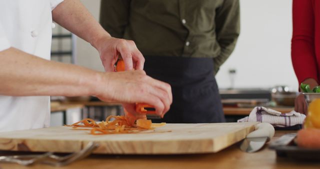 Chef Peeling Carrots in Kitchen during Cooking Class - Download Free Stock Images Pikwizard.com