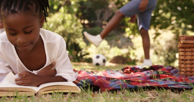 Young Girl Reading on Picnic Blanket with Soccer Background - Download Free Stock Images Pikwizard.com