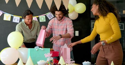 Colleagues enjoying baby shower party preparation at workplace