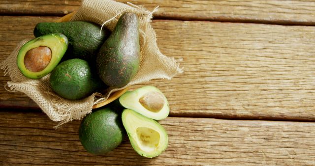 High angle view of avocados in jute fabric placed on wooden table 4K 4k