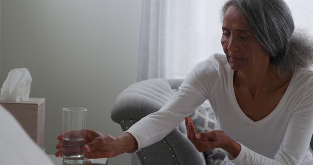 Concerned Elderly Woman Reaching for Glass of Water at Home - Download Free Stock Images Pikwizard.com