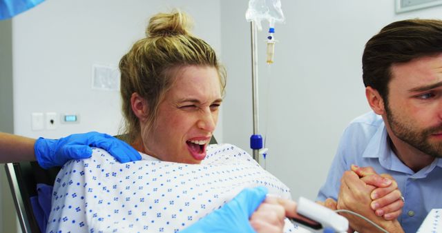 A Caucasian woman in labor experiences intense contractions as a healthcare professional assists her, with a concerned Caucasian man by her side, with copy space. The image captures the emotional intensity of childbirth, with the support of medical staff and loved ones.