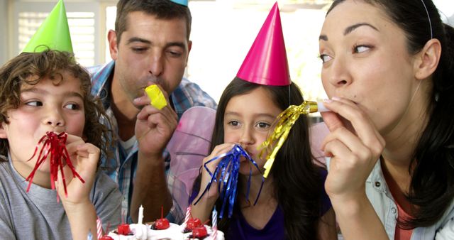 Family Celebrating at a Birthday Party with Party Hats and Blowers - Download Free Stock Images Pikwizard.com