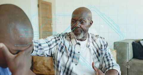Senior man reaching and comforting adult son on couch with blue health interface overlay