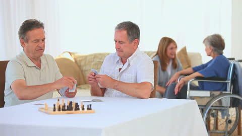Retired Men Playing Cards and Socializing in Senior Living Community