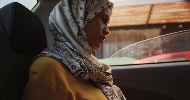 Contemplative Woman Wearing Hijab Seated in Car - Download Free Stock Images Pikwizard.com