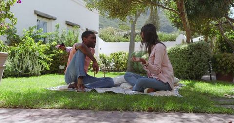 Diverse Couple Enjoying Serene Picnic in Sunny Garden
