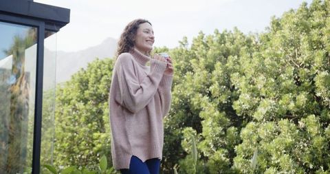 Woman Enjoying Morning Coffee on Patio Amidst Scenic Nature