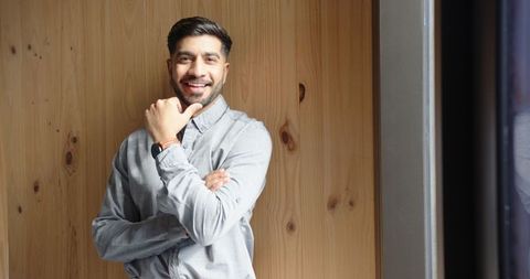 Smiling professional indian man relaxing in modern office space