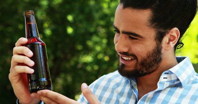 Smiling Man Holding Bottled Beverage Outdoors - Download Free Stock Images Pikwizard.com