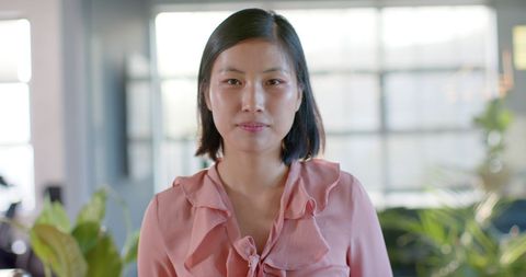 Confident Asian Businesswoman in Sunlit Office