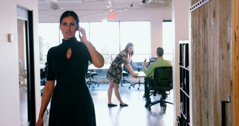 Businesswoman on Mobile Phone Walking in Modern Office