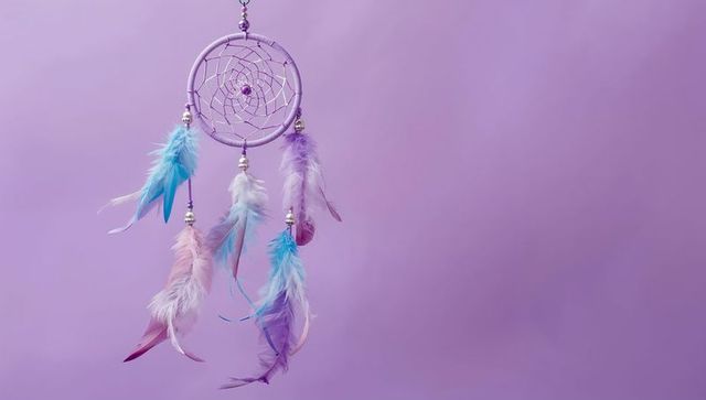 Boho Dreamcatcher with Pastel Feathers Against Lavender Background