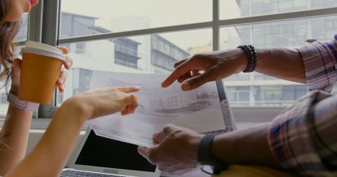 Diverse Team Reviewing Architectural Plans in Modern Office
