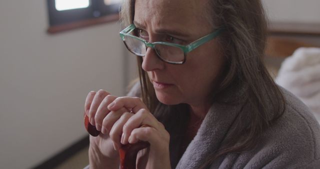 Worried Senior Woman with Cane Indoors in Thoughtful Moment - Download Free Stock Images Pikwizard.com