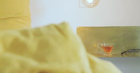 Cozy bedroom corner with glass teacup and warm tones