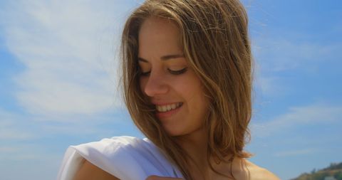 Smiling Woman Enjoying Sunny Beach Day with Sarong