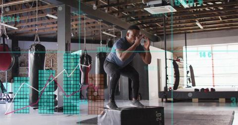 Male athlete jumping on 20-inch plyo box in gym with fitness data overlay