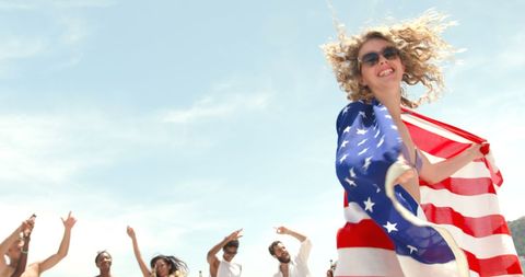 Joyful Woman Celebrating with American Flag at Beach Gathering