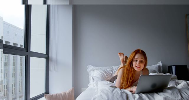 Woman Relaxing on Bed While Using Laptop in Cozy Minimalistic Room - Download Free Stock Images Pikwizard.com