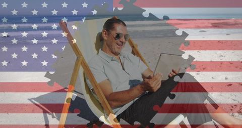 Man Relaxing on Beach with Tablet Blended with American Flag and Puzzle