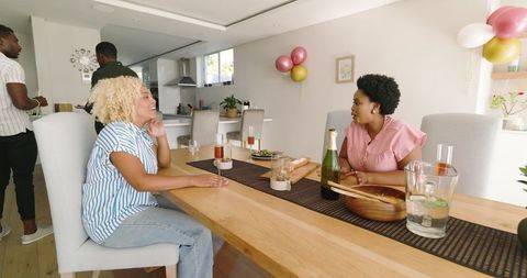 Friends Enjoying Mealtime and Laughter at Home Celebration