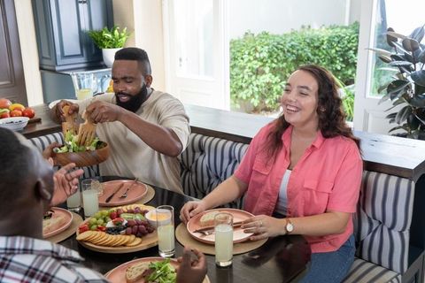 Friends Enjoying Gathered Meal in Cozy Kitchen Setting