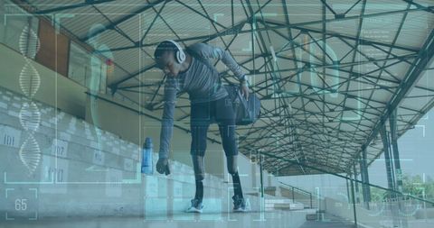 Athlete Wearing Headphones Examining Fitness Data at Track Stadium