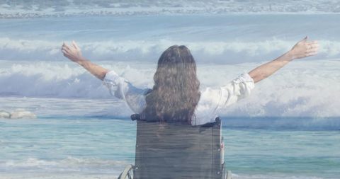 Double exposure of disabled woman by the sea celebrating freedom