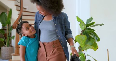 Happy Mother Welcoming Son Returning from School in Hallway