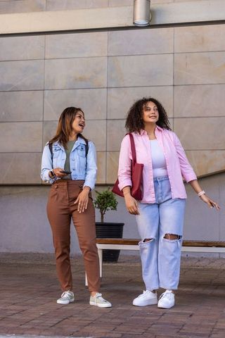 African american friends walking and chatting in casual urban denim fashion street style