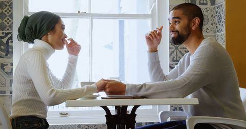 Couple Sharing Joyful Conversation Over Meal in Restaurant