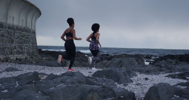 Two Women Running Along Rocky Beach - Download Free Stock Images Pikwizard.com