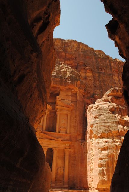Petra's iconic Treasury building, also known as Al-Khazneh, framed by narrow canyon walls. Highlighting ancient architectural marvels and adventure travel. Ideal for articles on historical places, travel guides, educational content about world history, and posts promoting tourism to Jordan's important sites.