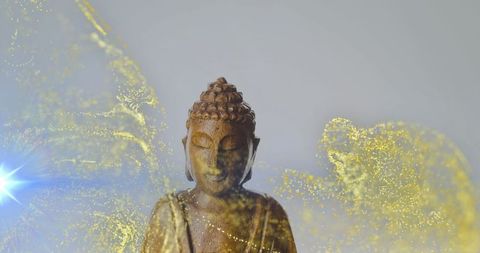 Wooden buddha statue with golden particles and lens flare