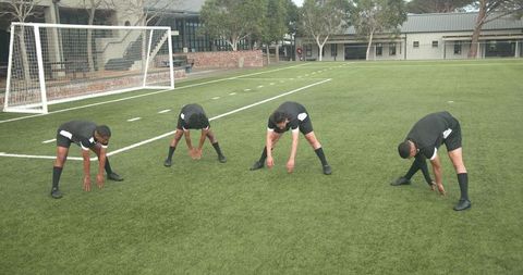 Soccer Players Stretching on Field for Practice Session