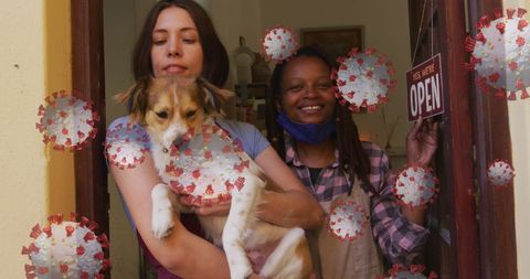 Diverse artisans holding dog amidst covid-19 concept with open sign