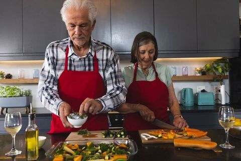 Senior Couple Relaxing While Cooking Together in Modern Kitchen