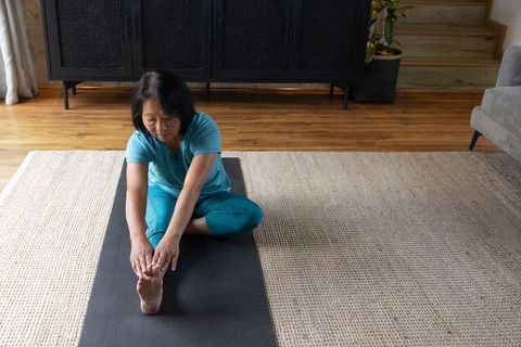 Senior Asian Woman Practicing Stretching at Home for Fitness