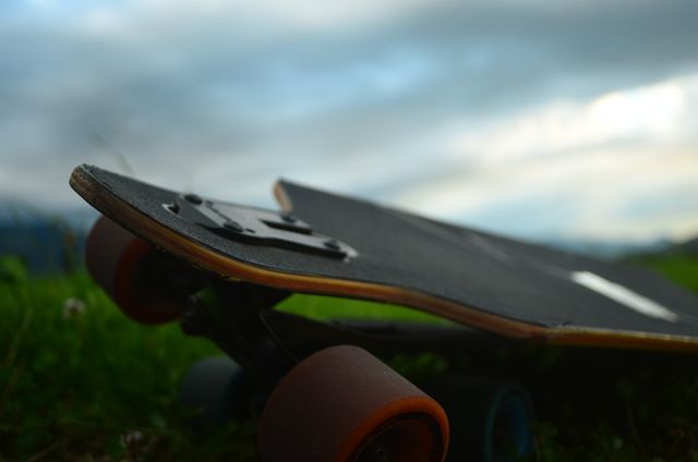 Close-up of Skateboard on Grass with Cloudy Sky - Download Free Stock Photos Pikwizard.com